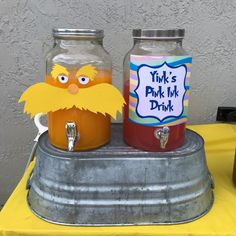 two jars with drinks in them sitting on top of a table