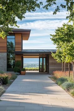 the entrance to a modern home surrounded by trees