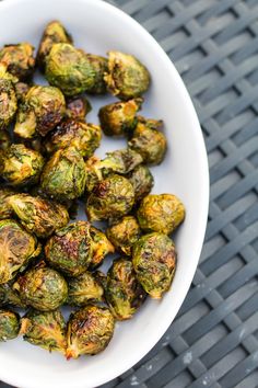 a white bowl filled with brussel sprouts on top of a table