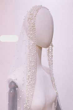 a white mannequin with pearls on it's head