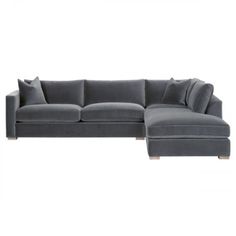 a gray sectional couch with pillows on it