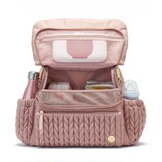 the pink diaper bag is packed with its contents and it's zipper open