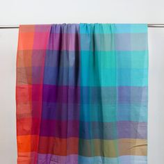 a multicolored scarf hanging on a clothes line with white background and no people