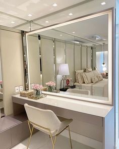 a large mirror sitting on top of a counter next to a white chair and table