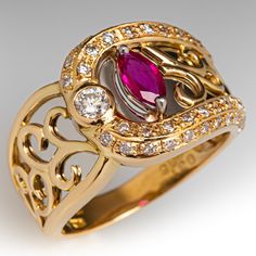 This fantastic 18K yellow gold ring features a pierced design filled with scroll details that are backed with curved platinum backgrounds. The ring is accented with one (1) prong set marquise cut natural ruby, one (1) bezel set round brilliant cut diamond, and forty-six (46) bead set round brilliant cut diamonds. The ring measures 12.3mm at the top, rises 4.4mm above the finger, tapering to 2.9mm wide and 0.8mm thick at the base of the shank. "0.31 D038 Pt900 18K is stamped on the inside shank. It is currently a size 5.75. Elegant Yellow Gold Ruby Ring With Intricate Design, Luxury Ruby Marquise Cut Ring For Formal Occasions, Luxury Ruby Ring Marquise Cut For Formal Events, Luxury Marquise Cut Ruby Ring For Formal Occasions, Luxury Marquise Cut Yellow Gold Ruby Ring, Luxury Marquise Cut Ruby Ring In Yellow Gold, Luxury Yellow Gold Ruby Ring With Marquise Cut, Luxury Yellow Gold Marquise Cut Ruby Ring, Elegant Marquise Ruby Ring With Diamond Cut