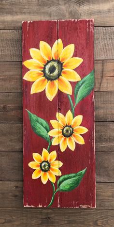 a wooden sign with sunflowers painted on it