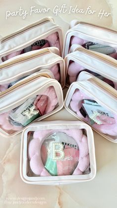 four white bags filled with pink items on top of a table