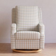 a rocking chair sitting on top of a hard wood floor next to a white wall