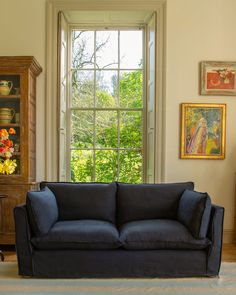 a blue couch sitting in front of a window