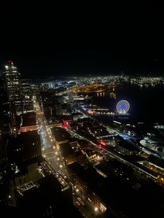 an aerial view of a city at night with lights on and fireworks in the sky