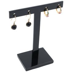 a pair of earrings on a black stand