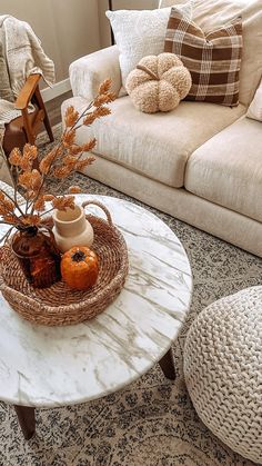 a living room filled with furniture and pillows on top of a white marble coffee table