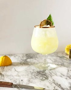 a glass filled with lemonade sitting on top of a table