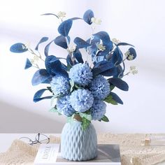 a blue vase filled with flowers on top of a table