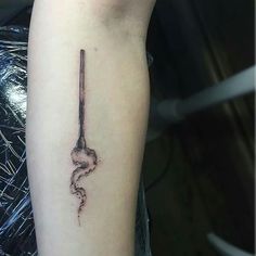 a tattoo on the arm of a woman with a snake in it's tail