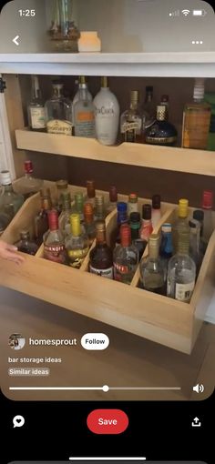 an open cabinet filled with liquor bottles on top of a counter