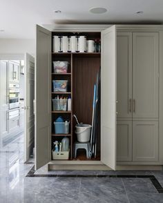 an open closet with cleaning supplies and other items on the shelves in it's center