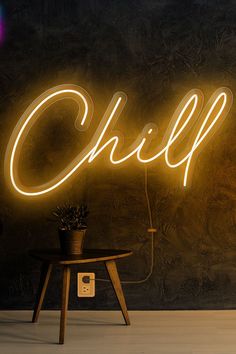 a neon sign that says chill on the wall next to a table with a potted plant