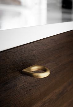 a close up of a wooden drawer with a metal handle