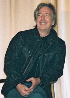 a man sitting in a chair smiling for the camera