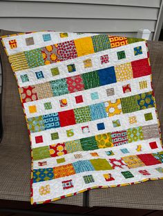 a multicolored patchwork quilt sitting on top of a chair