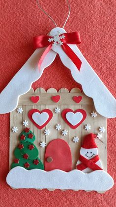 an ornament is hanging on the wall in front of a house with hearts and snowflakes