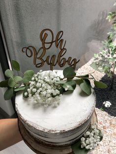 a cake with white frosting and greenery on top that says oh baub