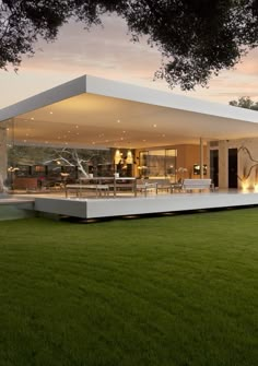 a modern house with grass and trees in the background