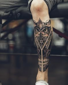 a man with an owl tattoo on his leg