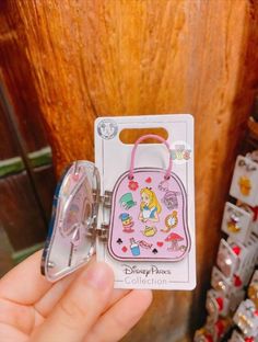 someone is holding up a disney princess purse shaped keychain and it's packaging