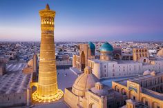 an aerial view of the old city and its minarets at dusk with lights on