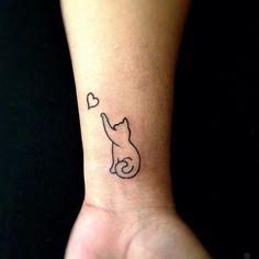 a cat with a heart tattoo on it's left wrist is seen in this image