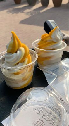 two desserts in plastic cups sitting on top of a table