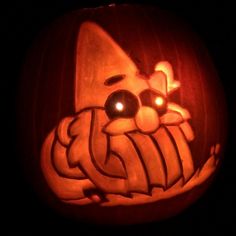 a carved pumpkin with an image of a cat on it's face in the dark