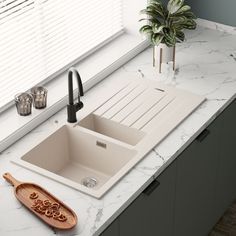 a kitchen sink sitting on top of a counter next to a cutting board and utensils