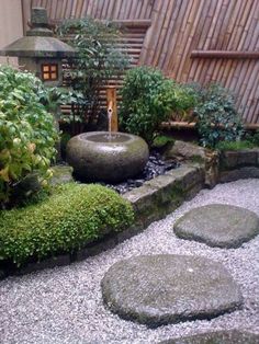 a small garden with rocks and water features in the center, surrounded by greenery