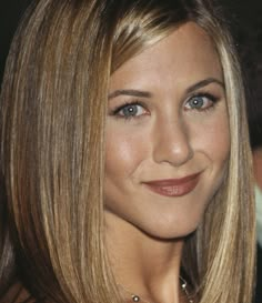 a close up of a woman with blonde hair and blue eyes smiling at the camera