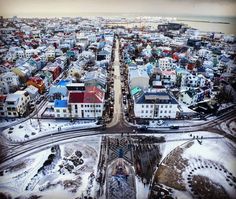 an aerial view of a city in the winter with lots of snow on the ground