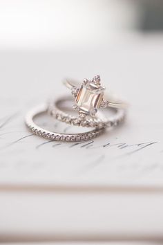 two wedding rings sitting on top of a piece of paper next to each other,