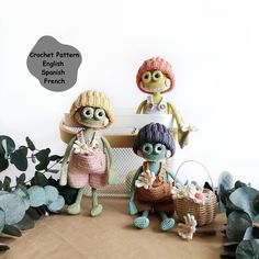 three knitted dolls sitting next to each other in front of plants and potted plants