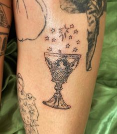 a woman's leg with tattoos on her legs and an image of a vase