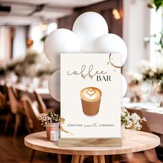 a coffee bar sign sitting on top of a wooden table next to balloons and potted plants