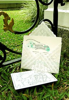 an open envelope sitting on the ground in front of a mailbox and gate with writing on it