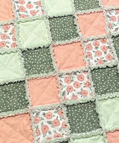 a patchwork quilt with pink and green flowers on it's edges, in the shape of squares