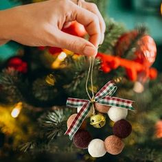 someone is decorating a christmas tree with ornaments