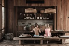 two children sitting on a bench in a room