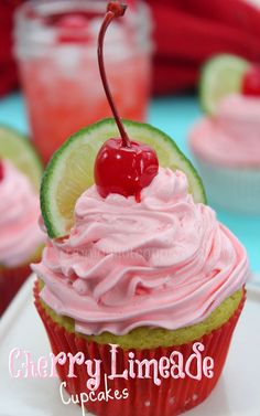 cupcakes with pink frosting and a cherry on top are sitting on a plate