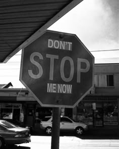 a red stop sign sitting on the side of a road next to a parking lot