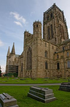 an old church with many windows and stone benches in the foreground, on a sunny day