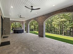 an outdoor living area with brick pavers and ceiling fan